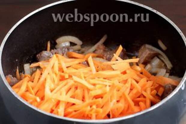 Морковь можно уложить одним слоем и не перемешивать, а можно смешать её вместе с луком. Подсолить. Поджарить смесь овощей с мясом 2-3 минуты. Морковь станет  не мягкой, а «послушной» и немного отдаст свой цвет.