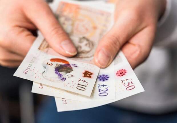 Hands holding British bank notes pounds