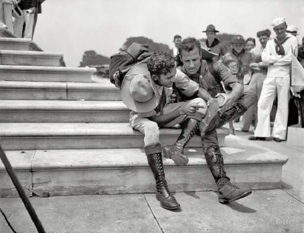 Бойскауты рассматривают свои ботинки после 8000 миль похода во время участия в первом Boy Scout Jamboree. 1937 год.