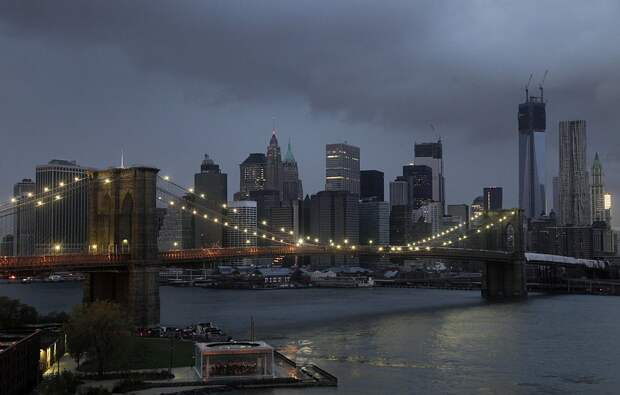 Огни на Бруклинском мосту исправно работают, на фоне нижнего Манхэттена, который остался без электричества