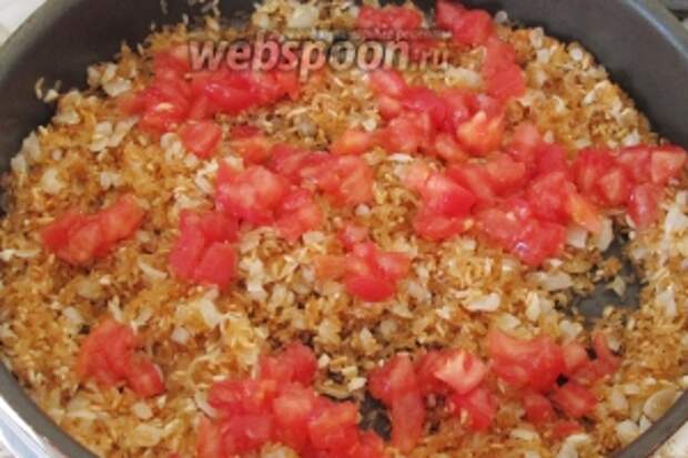 Когда мы закончили обжаривать рис, выложим на сковороду кусочки помидора. Перемешивать не надо.