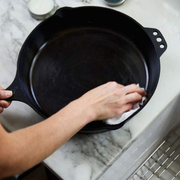 Smithey Ironware cast iron skillet being cleaned with soap by hand.