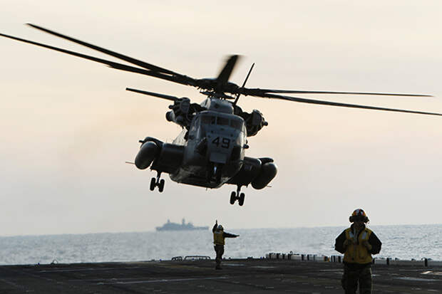 Вертолет MH-53 Sea Stallion садится на десантный корабль Wasp. Учения морской пехоты США в феврале 2012 года у побережья Северной Каролины.