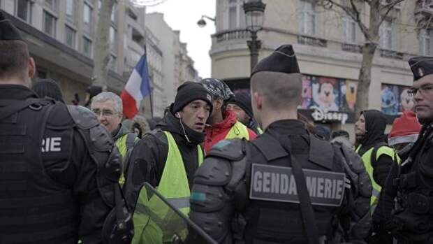 Сотрудники полиции и участники акции протеста движения автомобилистов желтые жилеты в районе Триумфальной арки в Париже. 15 декабря 2018
