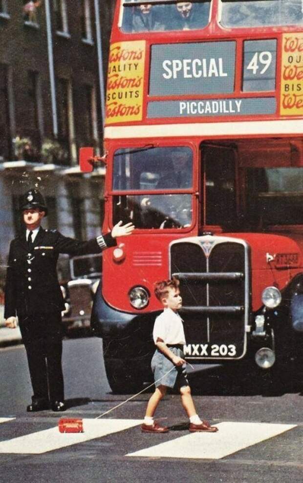 Двухэтажный автобус пропускает мальчика, переходящий дорогу, 1960 год ... и да, у мальчика тоже есть двухэтажный автобус. история, люди, факты