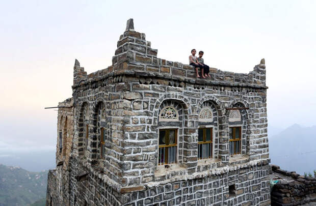 Мальчики сидят на крыше своего дома.  Фото: Abduljabbar Zeyad.