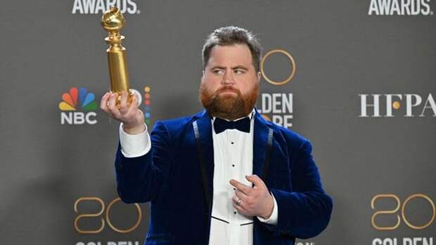 Paul walter hauser holding a golden globe award