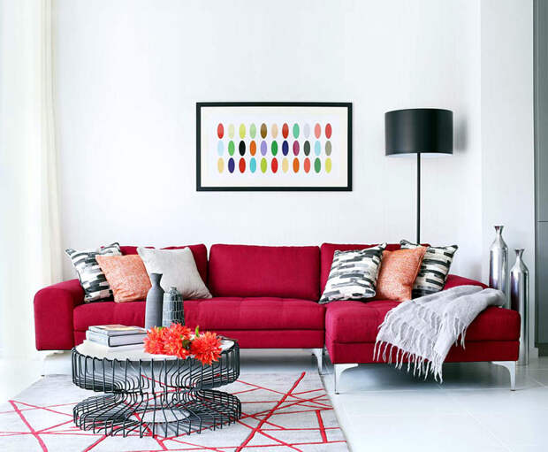 ярко-красный диван в дизайне интерьера гостиной комнаты
