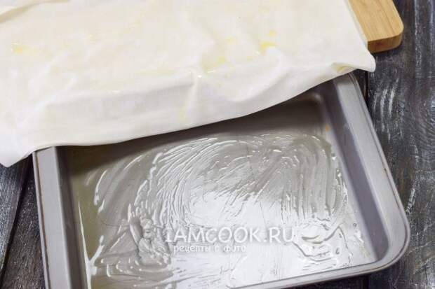 Смазать тесто и форму маслом
