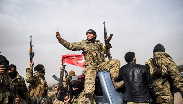 Боец сирийской оппозиции фотографирует колонну турецких солдат около сирийской границы. Архивное фото
