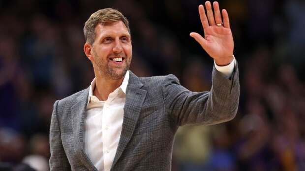 Dirk Novitzki waves to the crowd at a Mavs basketball game.