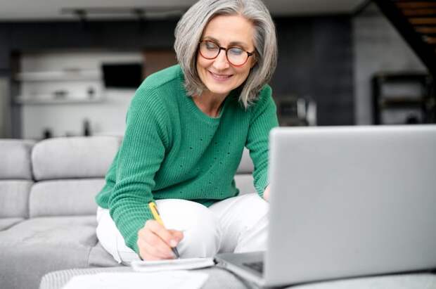 Person sitting at a computer and doing paperwork.