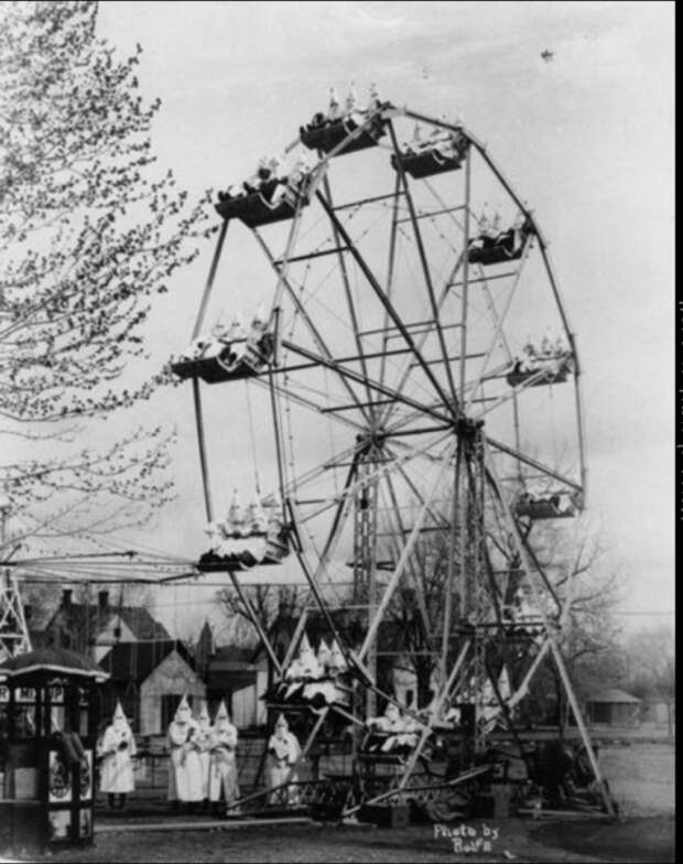 Члены организации Ку-Клукс-Клан катаются на колесе обозрения в 1925 году. Ку-клукс-клан - это ультраправая организация в США, отстаивавшая такие идеи, как превосходство белых или белый национализм. В середине XX века организация активно выступала также против коммунизма.
