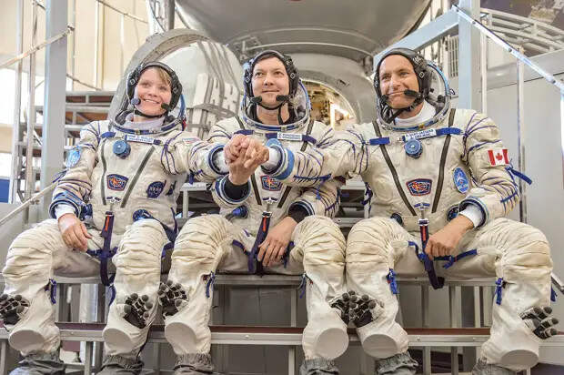 Soyuz MS-09 backup crew in front of the Soyuz spacecraft mockup.jpg