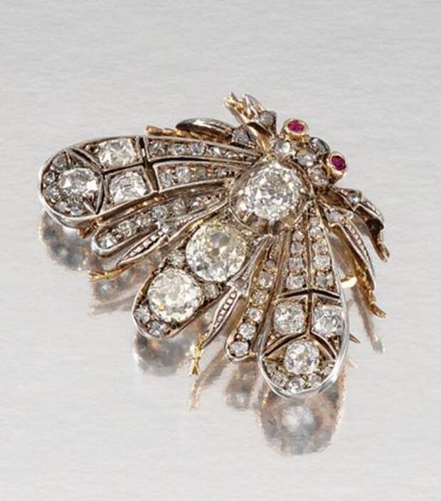 RUBY AND DIAMOND BROOCH/PENDANT, LATE 19TH CENTURY Designed as a moth, its wings, thorax and head set with circular-, rose-cut and cushion-shaped diamonds, its eyes highlighted with circular-cut rubies, later bale and brooch fitting, case.