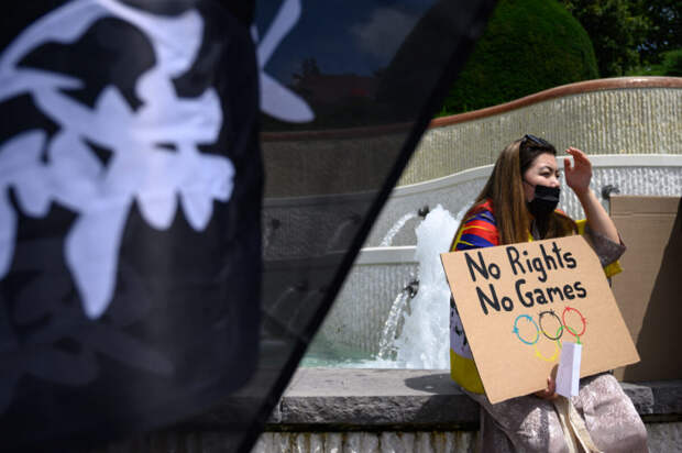 Женщина держит плакат во время акции протеста тибетских и уйгурских активистов против зимних Олимпийских игр 2022 года в Пекине перед музеем Олимпийских игр в Лозанне, Швейцария, 23 июня 2021 года