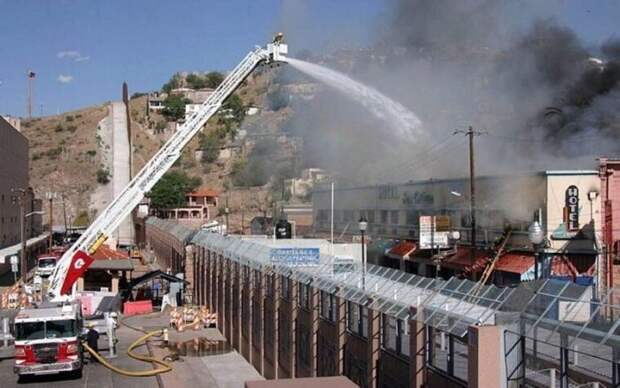 Пожарные из Аризоны, США, помогают мексиканским коллегам тушить пожар через пограничную стену.