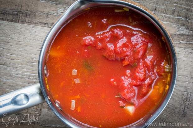 Влить томаты в собственном соку и воду. Довести до кипения, посолить, поперчить, добавить сахар (немного, так, чтобы сбалансировать кислоту томатов). Уменьшить огонь и варить 30-40 минут.