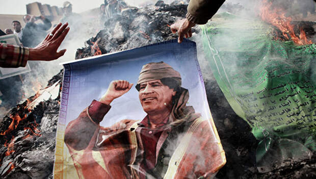 Житель Бенгази сжигает портрет Муаммара Каддафи. Архивное фото