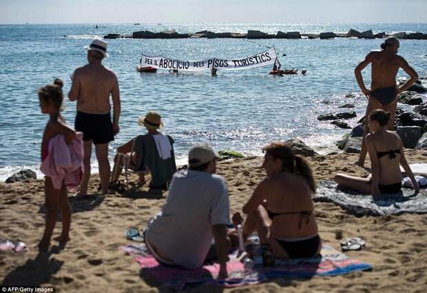 Надпись на транспаранте: "За отмену апартаментов для туристов" барселона, испания, каталония, местные жители, пляж, протест, протестующие, туризм