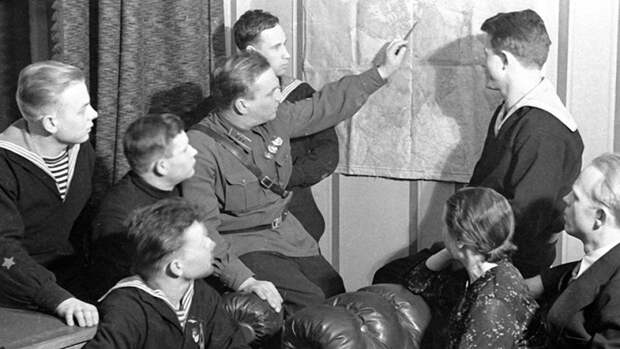 Валерий Чкалов показывает на карте маршрут своего перелета из Москвы в Ванкувер морякам с крейсера «Марат» и рабочим с московской кондитерской фабрики имени Марата