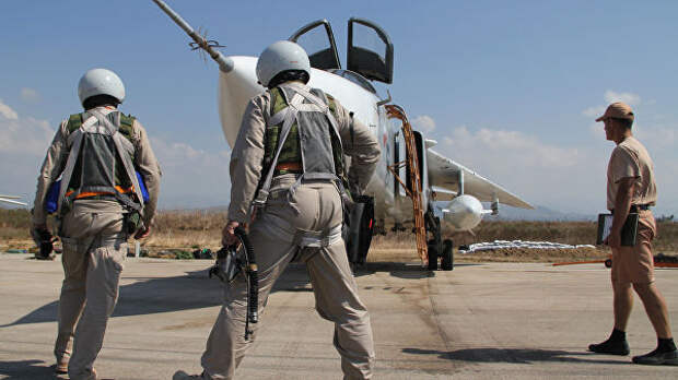 Российские летчики перед полетом у самолета Су-24 на авиабазе Хмеймим в Сирии