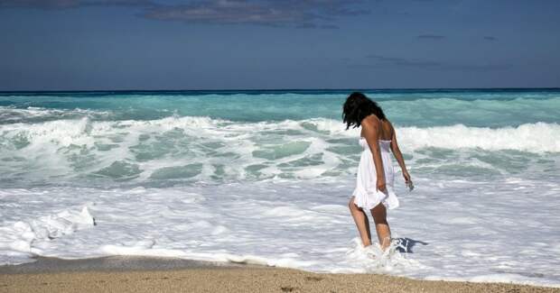 Девушка гуляет у моря