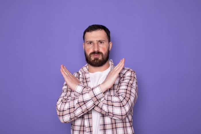 Person with their arms crossed as if saying no or no more.
