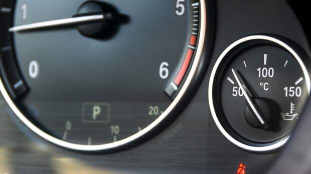 Coolant temperature gauge and tahometer on a car's dashboard. Ca