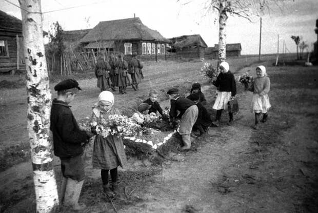Дети освобожденного г.Ржева Калининской обл. возлагают цветы на могилы советских бойцов. 1942 г.