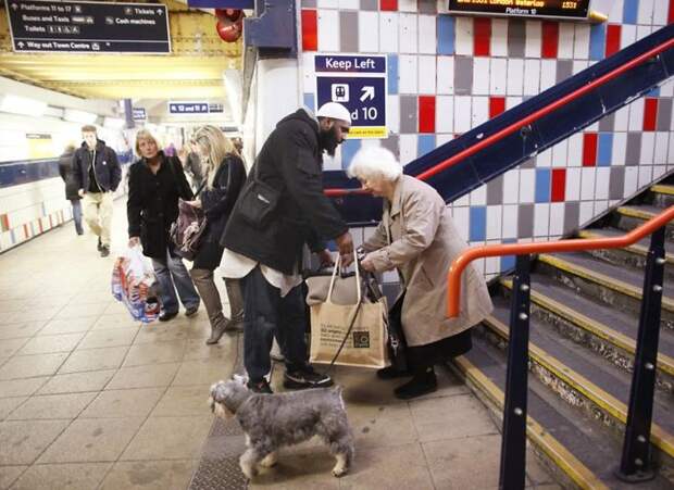 A Guy Helping An Old Woman Carry Her Stuff