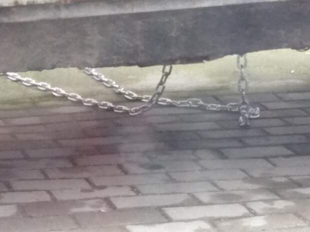 В Калининграде мужик припарковался на тротуаре, и чтобы его авто не эвакуировали, приковал машину цепями к дому
