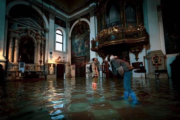 Фотограф гуляет по затопленным улицам Венеции, делая снимки трагической красоты города