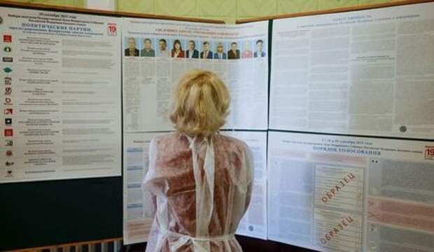 A member of a local election commission looks at an information board at a polling station on the first day of a three-day long parliamentary elections in the village of Tarbagatay, in the Republic of Buryatia, Russia September 17, 2021. RUETERS/Maxim Shemetov