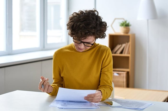 A person sitting at a desk and filling out paperwork.