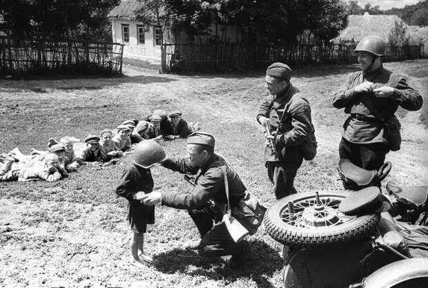 Солдаты 51-го отдельного мотоциклетного батальона 22-го танкового корпуса 38-й армии Юго-Западного фронта с советскими детьми. 1942 г. Солдаты 51-го отдельного мотоциклетного батальона 22-го танкового корпуса 38-й армии Юго-Западного фронта с советскими детьми. 1942 г.