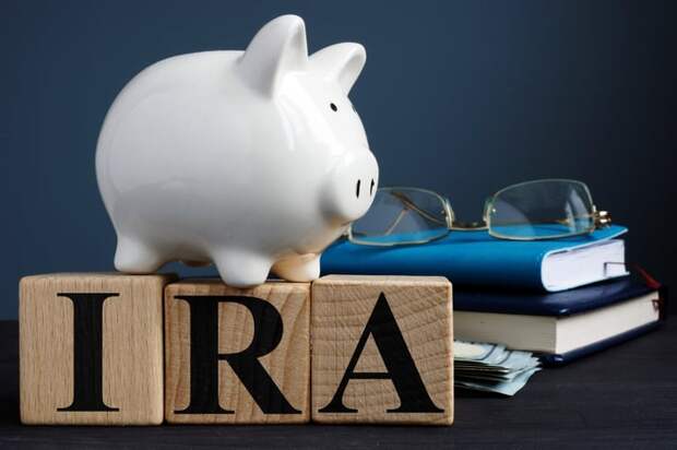A piggy bank sitting on top of blocks that spell out IRA.