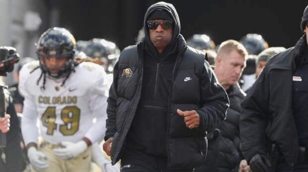 Deion Sanders runs onto the field with the Colorado football team.