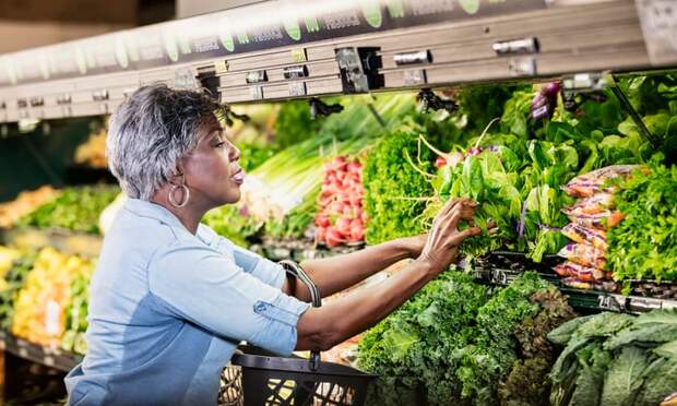 A person in a supermarket produce aisle.