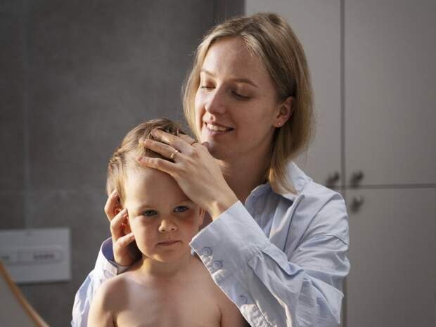 Мама трогает влажные из-за гипергидроза волосы у ребенка Мама трогает влажные из-за гипергидроза волосы у ребенка