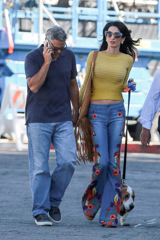 Амаль Клуни в джинсах клеш и желтой кофточке, Джордж Клуни в синих джинсах и черной футболке