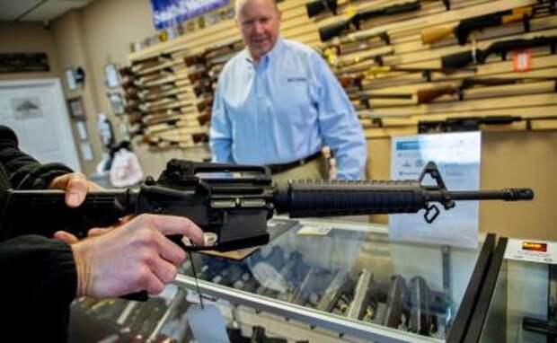 На фото: 38-летний Пол Беквар из Йорквилля, штат Иллинойс, готовится купить оружие у Барри Торфи, владельца оружейного магазина Bat Arms в Плано, штат Иллинойс