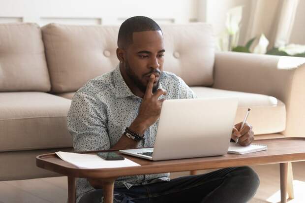 Young black man reviewing information on his laptop
