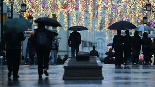 Прохожие на одной из улиц Москвы во время дождя