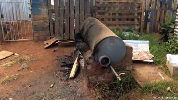 A large rusty boiler rests on the ground