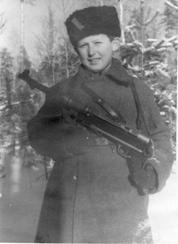 Советский партизан-подросток Коля Любичев из партизанского соединения А.Ф. Федорова с трофейным немецким 9-мм пистолетом-пулеметом МР-38 в зимнем лесу. 1943 г.