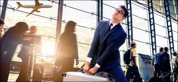 A man carrying a heavy bag through an airport
