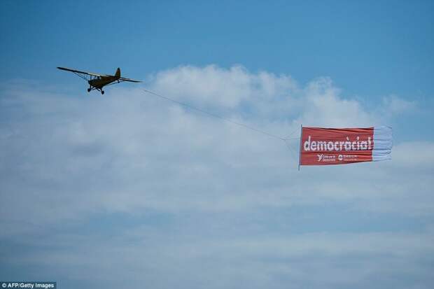 Примечателен и баннер в небе с надписью "Демократия" барселона, испания, каталония, местные жители, пляж, протест, протестующие, туризм