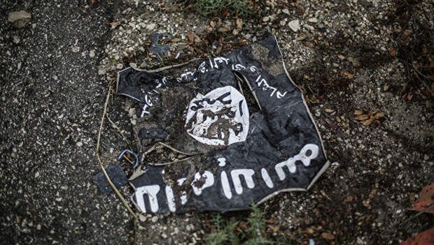 Втоптанный в грязь флаг запрещенной в России радикальной исламистской организации ИГ. Архивное фото
