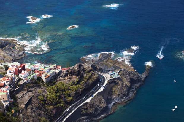 Aerial view of a rocky coast on Tenerife with a village on the left.